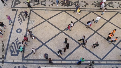 traditional portuguese pavement calçada street with people passing by in lisbon Portugal slow motion