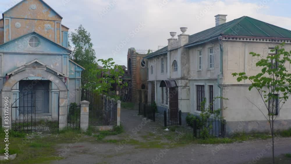 Ghost (haunted) town with an abandoned houses, a church and a buildings on a deserted streets. Aerial low angle view Ghost (haunted) town with an abandoned houses, a church and a buildings on a deserted streets. Aerial low angle view
