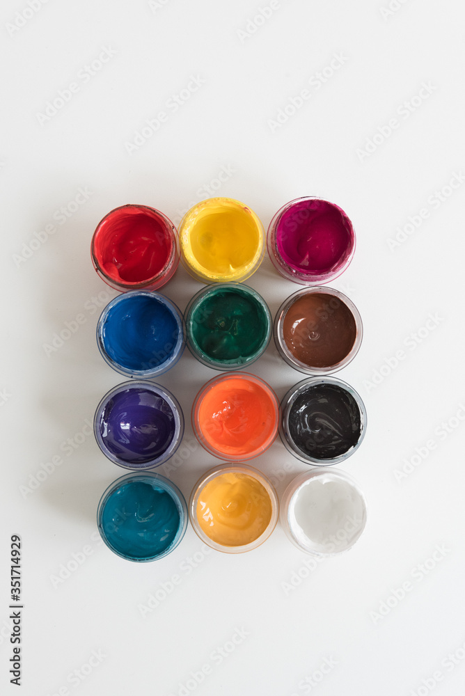 Open cans of paint, top view. Variety, many colors of gouache. Background, texture. Open cans of paint, top view. Variety, many colors of gouache. Background, texture.