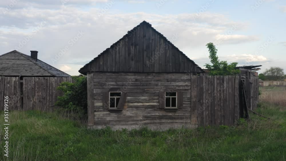 Abandoned wooden house on the deserted outskirts of the village. Aerial view. Low angle shot Abandoned wooden house on the deserted outskirts of the village. Aerial view. Low angle shot