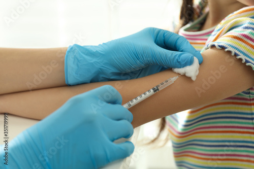 Doctor vaccinating little child in clinic  closeup