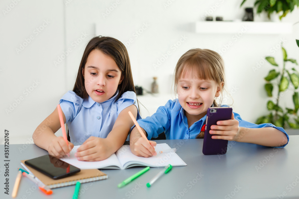Pretty stylish schoolgirls studying during her online lesson at home, social distance during quarantine, self-isolation, online education concept Pretty stylish schoolgirls studying during her online lesson at home, social distance during quarantine, self-isolation, online education concept