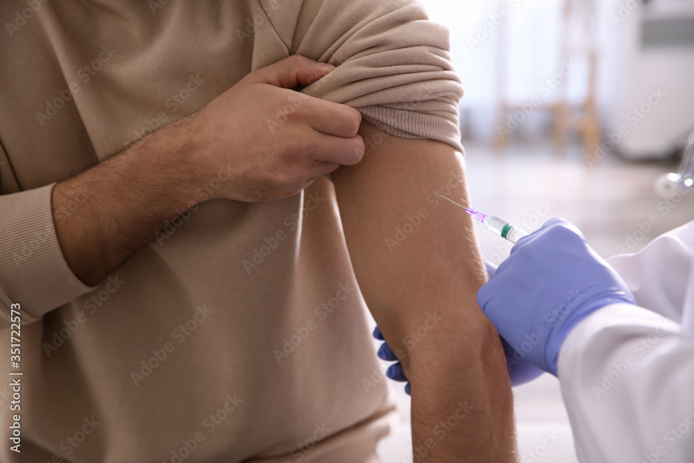 Doctor giving injection to patient in hospital, closeup. Vaccination concept Doctor giving injection to patient in hospital, closeup. Vaccination concept