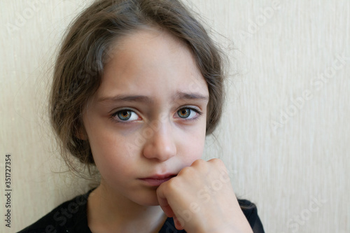 Portrait of a girl of 8 years old crying and sad on a light background