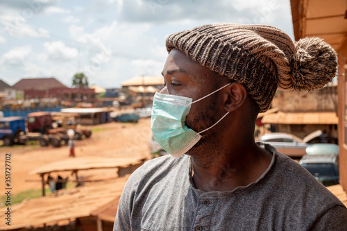 Фотография african man wearing a face mask outside