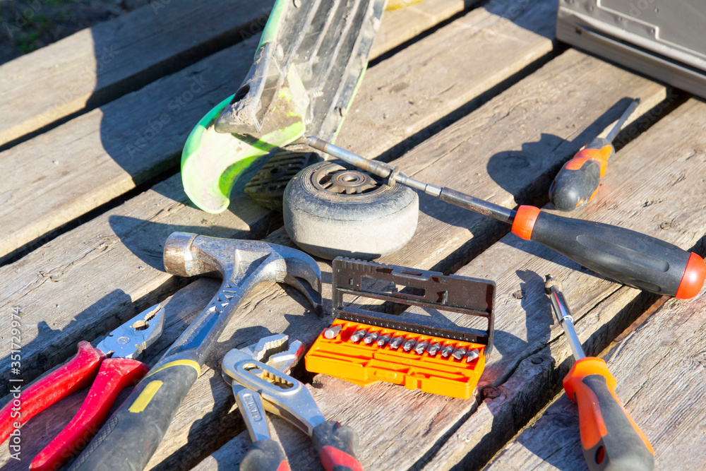 working tools lie on a wooden pallet. next to the wheel of the scooter. working tools lie on a wooden pallet. next to the wheel of the scooter.