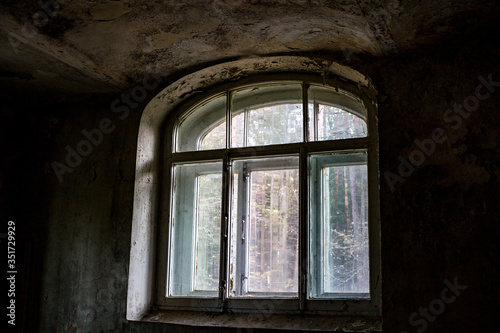 A semicircular arch window in an old abandoned building
