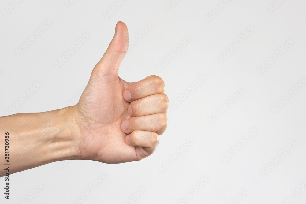 Hand with raised thumb on a white background. Hand showing like. The concept of 