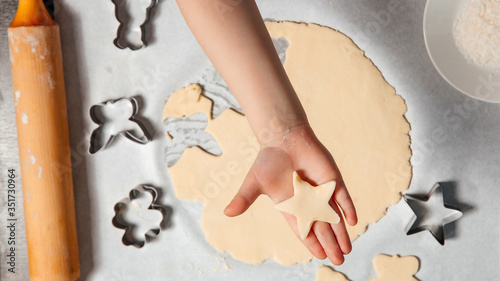 Baby's hands are making cookies out of dough. Creative concept with children and baking.