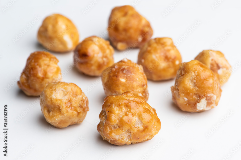 Roasted hazelnuts in caramel on a white background Roasted hazelnuts in caramel on a white background