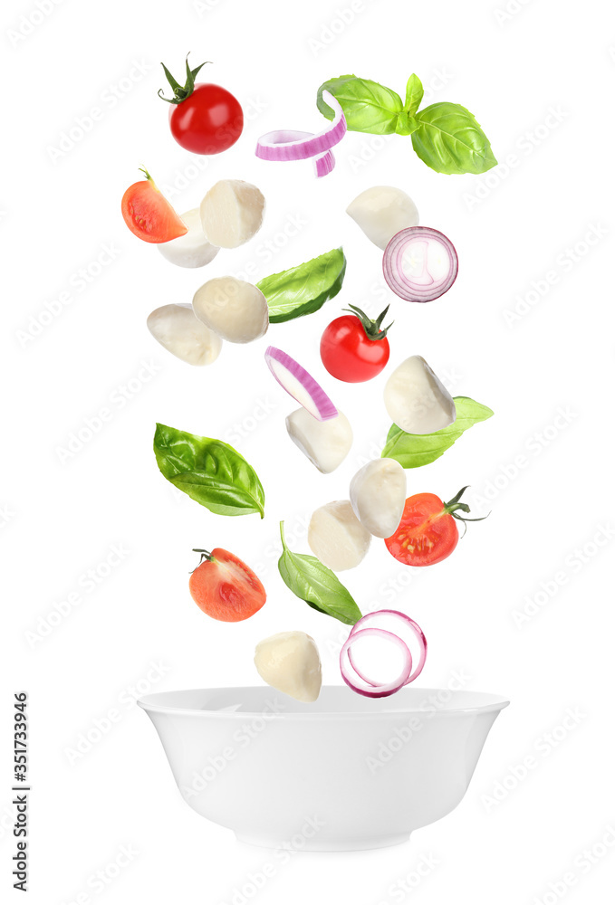 Mozzarella cheese, tomatoes, onion and basil leaves falling into bowl on white background Mozzarella cheese, tomatoes, onion and basil leaves falling into bowl on white background