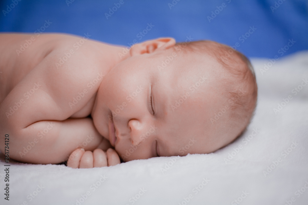 Sweet sleeping newborn baby boy on white bedspread Sweet sleeping newborn baby boy on white bedspread
