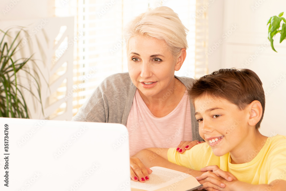 Mom helping son with online lesson. Mom helping son with online lesson.