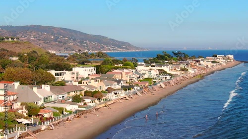 4K Aerial drone shot of Malibu Beach coastline in California with the blue Pacific Ocean with waves coming in and beach with houses in background
