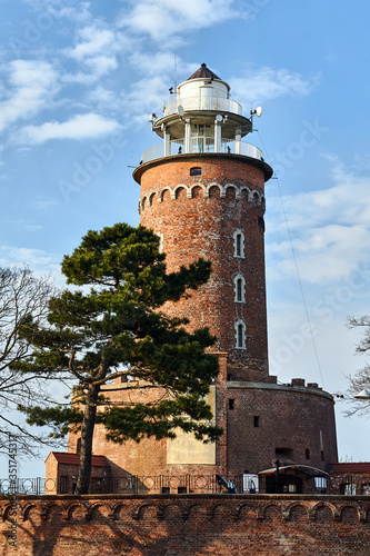 A red brick lighthouse at the entrance to the port in the city of Kolobrzeg.