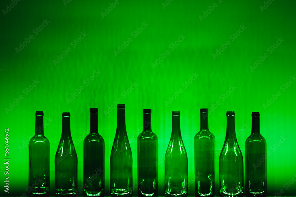 abstract empty wine bottles with green illumination abstract empty wine bottles with green illumination