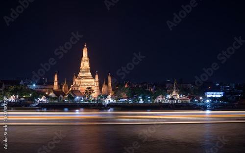 Night photo illuminated old Wat Arun Ratchawararam Ratchawaramahawihan or Wat Arun "Temple of Dawn" - Buddhist temple in Bangkok Yai district, Thailand, on the Thonburi bank of Chao Phraya River.
