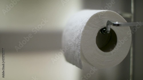 Grabbing a piece of toilet paper. Pulling a piece off a roll of toilet paper. Shot in 4k.