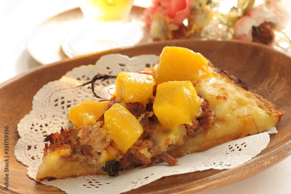 Piece of tropical fruit mango and beef Pizza on wooden plate Piece of tropical fruit mango and beef Pizza on wooden plate