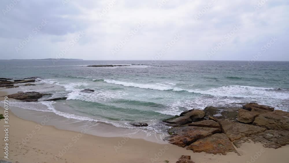 Sandy ocean beach with rocks and waves Sandy ocean beach with rocks and waves