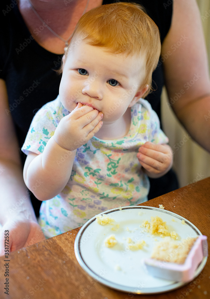 Girl on her first birthday eating her birthday cake Girl on her first birthday eating her birthday cake