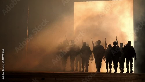 group of soldiers walk through smoke , slow motion.