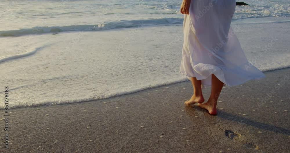 Woman walking on beach during sunset Stock Video | Adobe Stock