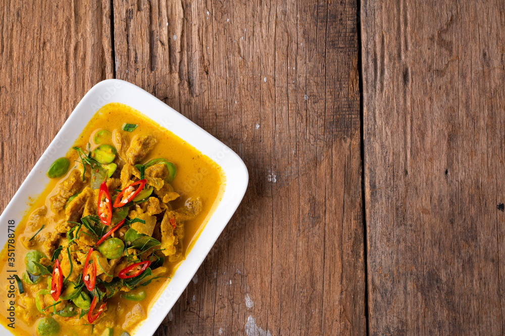 Spicy stir fried pork with Cluster Bean (Bitter Bean or stink beans) popular southern Thai food on wood background. Spicy stir fried pork with Cluster Bean (Bitter Bean or stink beans) popular southern Thai food on wood background.