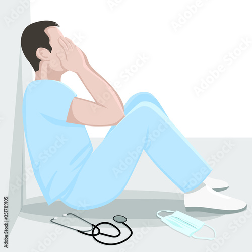 Exhausted doctor sitting on the floor in corridor at hospital. COVID-19, Coronavirus pandemic. Tired medical worker crying.