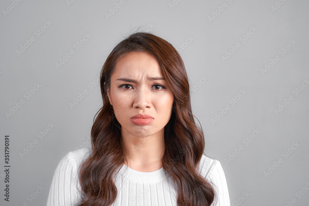 young beautiful sad woman serious and concerned looking worried and thoughtful facial expression feeling depressed isolated grey background in sadness and sorrow emotion young beautiful sad woman serious and concerned looking worried and thoughtful facial expression feeling depressed isolated grey background in sadness and sorrow emotion
