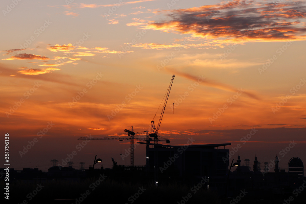evening sky with sunset and industrial cranes object