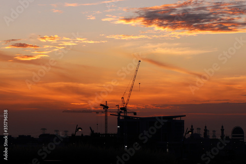evening sky with sunset and industrial cranes object