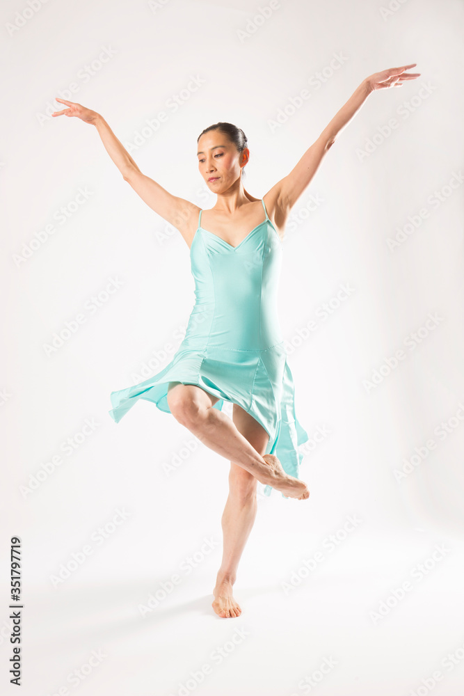 Adult woman dancing in the studio in a blue dress. Adult woman dancing in the studio in a blue dress.