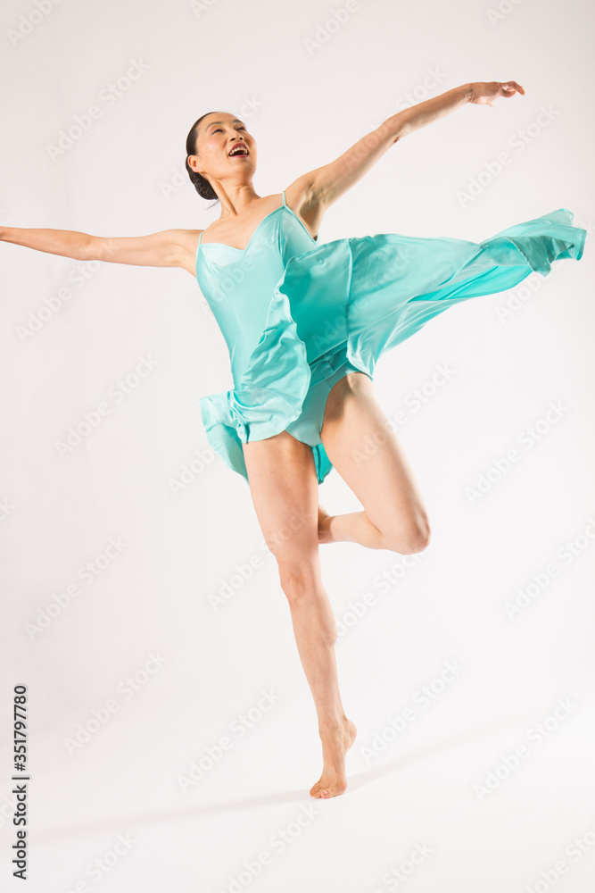 Adult woman dancing in the studio in a blue dress. Adult woman dancing in the studio in a blue dress.