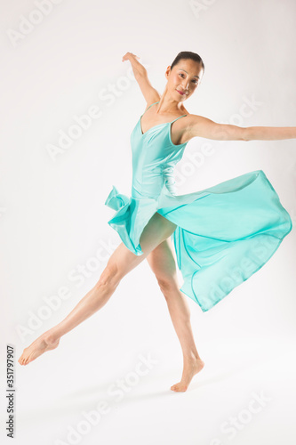 Adult woman dancing in the studio in a blue dress.