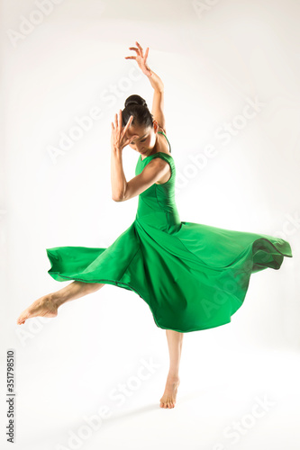 Adult woman dancing in the studio in a green dress.