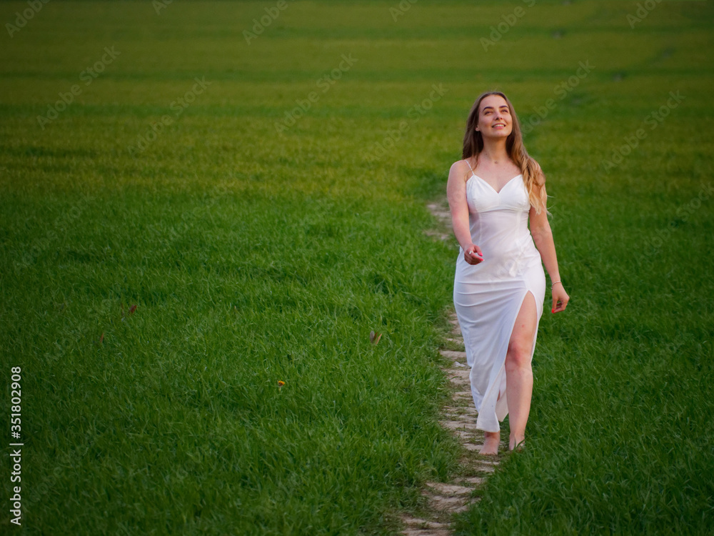 girl in a long white dress on a green field girl in a long white dress on a green field
