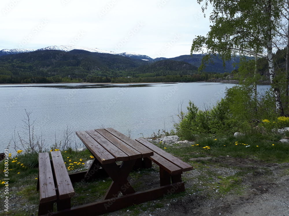 Obraz premium Wooden bench on the shores of the blue fjord
