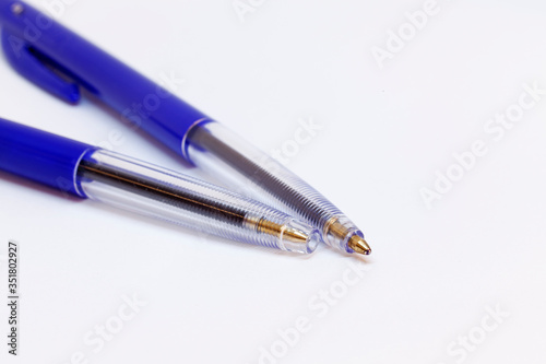 two plain blue ink pens on white background