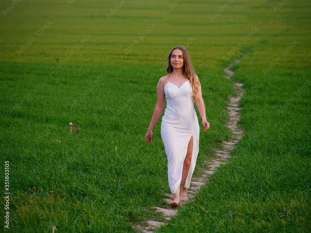 girl in a long white dress on a green field girl in a long white dress on a green field