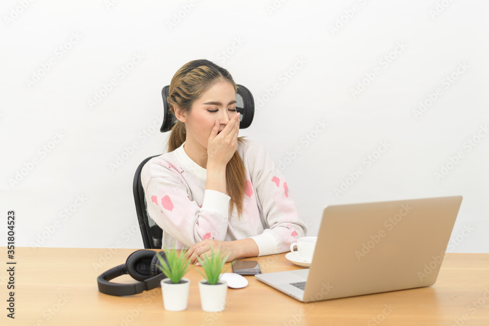 Photo of overworked tired asian business woman 25 years wearing office clothing yawning while sitting at table with laptop open isolated over white background Photo of overworked tired asian business woman 25 years wearing office clothing yawning while sitting at table with laptop open isolated over white background