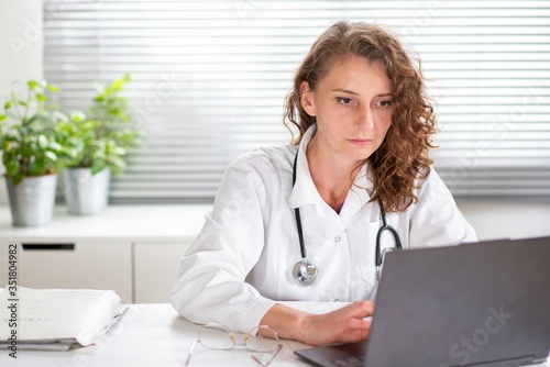 portrait of female doctor working on laptop telemedicine concept