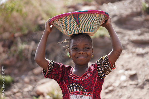 Gorgeous African Girl with Toothy Smile and Basket on Head photo