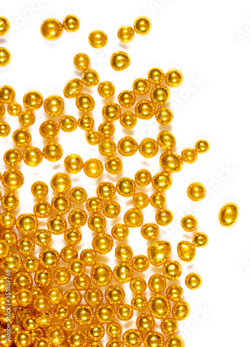 Small balls of gold on a white background.