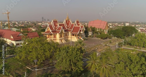 Wallpaper Mural Aerial forward shot of Buddhist temple amidst structures against sky on sunny day - Vientiane, Laos Torontodigital.ca