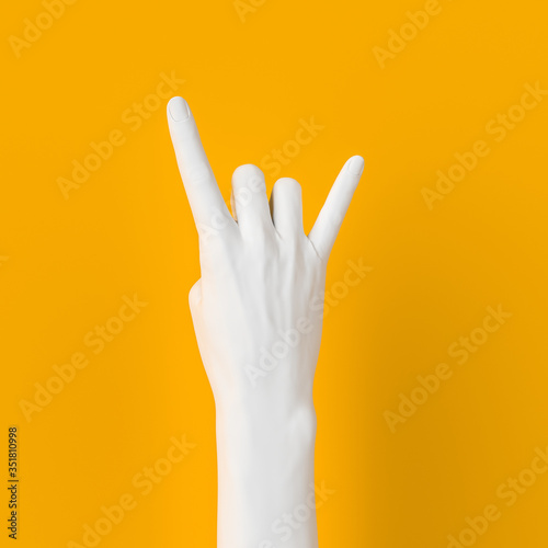 Rock hand sign, female hand punk rock gesture white color isolated on yellow, creative art protest banner, 3d rendering