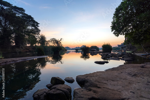 Beautiful landscape view of sunrise and old wooden boat drop nearly the river in front of guest house from Don Det the famous place for tourist to relaxing at Siphondon island, Laos. photo