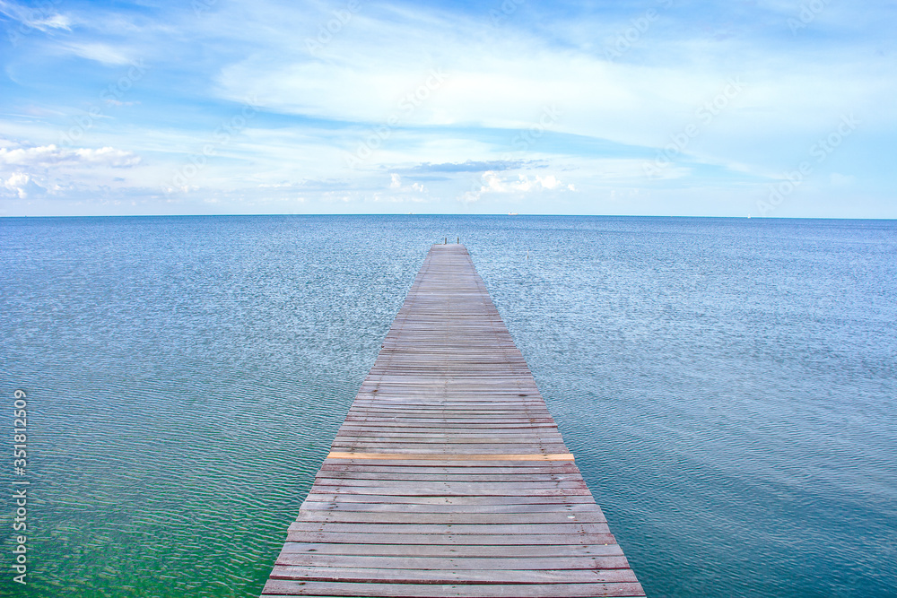 View of a wooden bridge stretching down to the sea