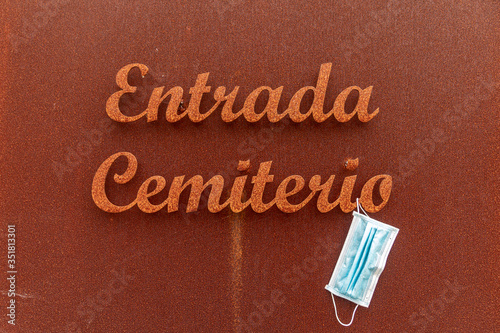 Dumbria cemetery entrance door with a surgical mask
