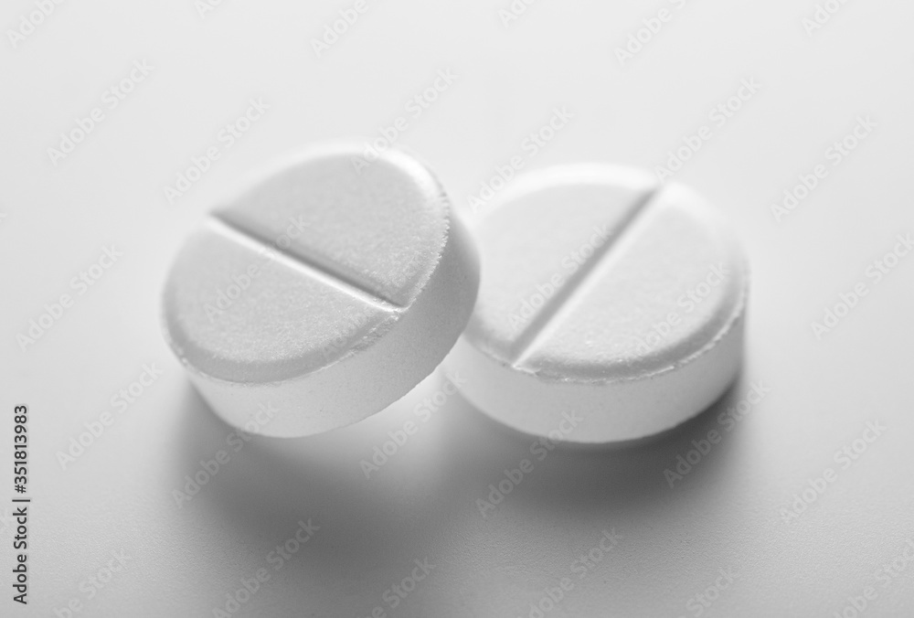 Two generic white tablets or pills in close up Two generic white tablets or pills in close up